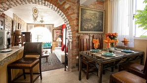 A dining area with a brick archway, a painting, and a table set for four.