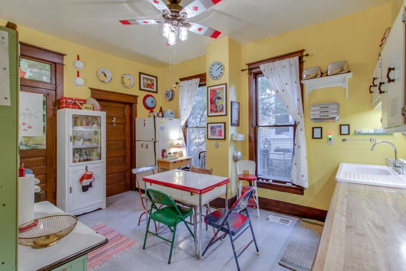 Une cuisine de taille réduite comprenant une table à manger, des chaises, un réfrigérateur et un évier.