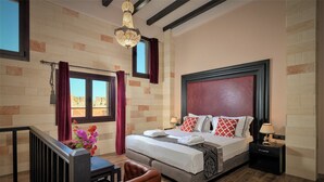 A hotel room with a large bed, a nightstand, a desk, and a chair. - Grand Master Suite (Rodos)