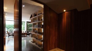 Un interior moderno con una estantería de madera, una zona de comedor y vistas al exterior.