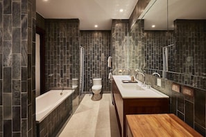 A modern bathroom with a freestanding bathtub, a double sink vanity, and a toilet. - Luxx Langsuan (Bangkok)