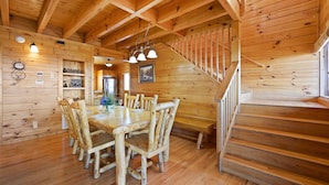 A wooden interior with a dining area featuring a wooden table and chairs, a staircase, and a wooden ceiling. - Specials! Stunning Views+Location. 4 King Beds w/ en suite. Hot Tub, Games! (Sevierville)