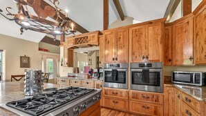 A kitchen with wooden cabinets, stainless steel appliances, and a granite countertop.