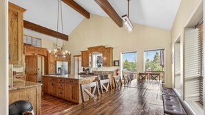A spacious kitchen with wooden cabinetry, a large island, and a dining area with benches.