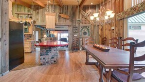 A spacious kitchen with a central island, wooden cabinetry, and a hanging chandelier. - Seasons at McCall - Indoor Pool - Game Room - Outdoor Hot Tub - Bar room - Pool table (McCall)