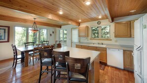 Una cocina amplia con armarios de madera, una isla grande y una zona de comedor con sillas.
