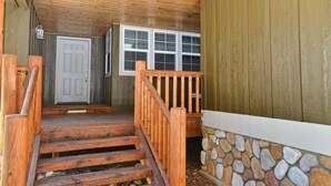 A wooden staircase leading to a door with a stone wall and a window. - Peace in the Pines: Woodland Oasis in Spring Mountain Ranch, Private Hot Tub (McCall)