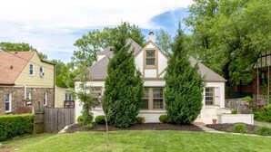 A two-story house with a front yard, a stone foundation, and a fenced backyard. - Boho Charm | Peaceful Neighborhood | 3BR/2.5 Bath (Nashville)
