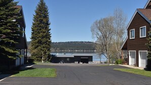 A residential driveway leading to a garage with a lake view.