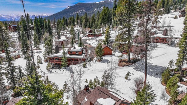 Ein schneebedecktes Bergresort mit Holzhütten und Skipisten.