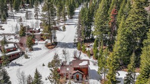 Ein schneebedecktes Skigebiet mit Chalets und einer Skipiste.