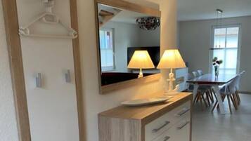 Une salle de bain moderne avec un meuble-lavabo en bois, un miroir et deux lampes fixées au mur.