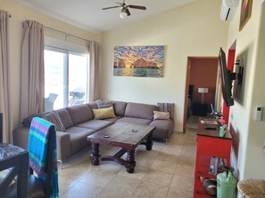 A living room with a sofa, a coffee table, and a painting on the wall.