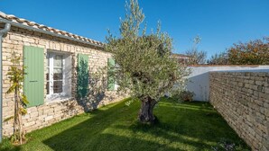 A stone building with green shutters and a well-maintained lawn. - Arte - Artist villa in the heart of la Noue (Sainte-Marie-de-Ré)