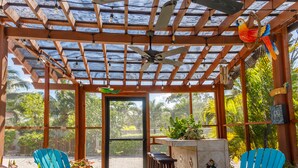 A covered outdoor seating area with wooden chairs and a bar. - The Luxury Poolhouse, Casa 2 at Casa de Shelley   Corozal, Belize (Ranchito, Corozal)