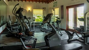 A gym with various exercise machines, a wooden ceiling, and a view of greenery outside. - The Luxury Poolhouse, Casa 2 at Casa de Shelley   Corozal, Belize (Ranchito, Corozal)