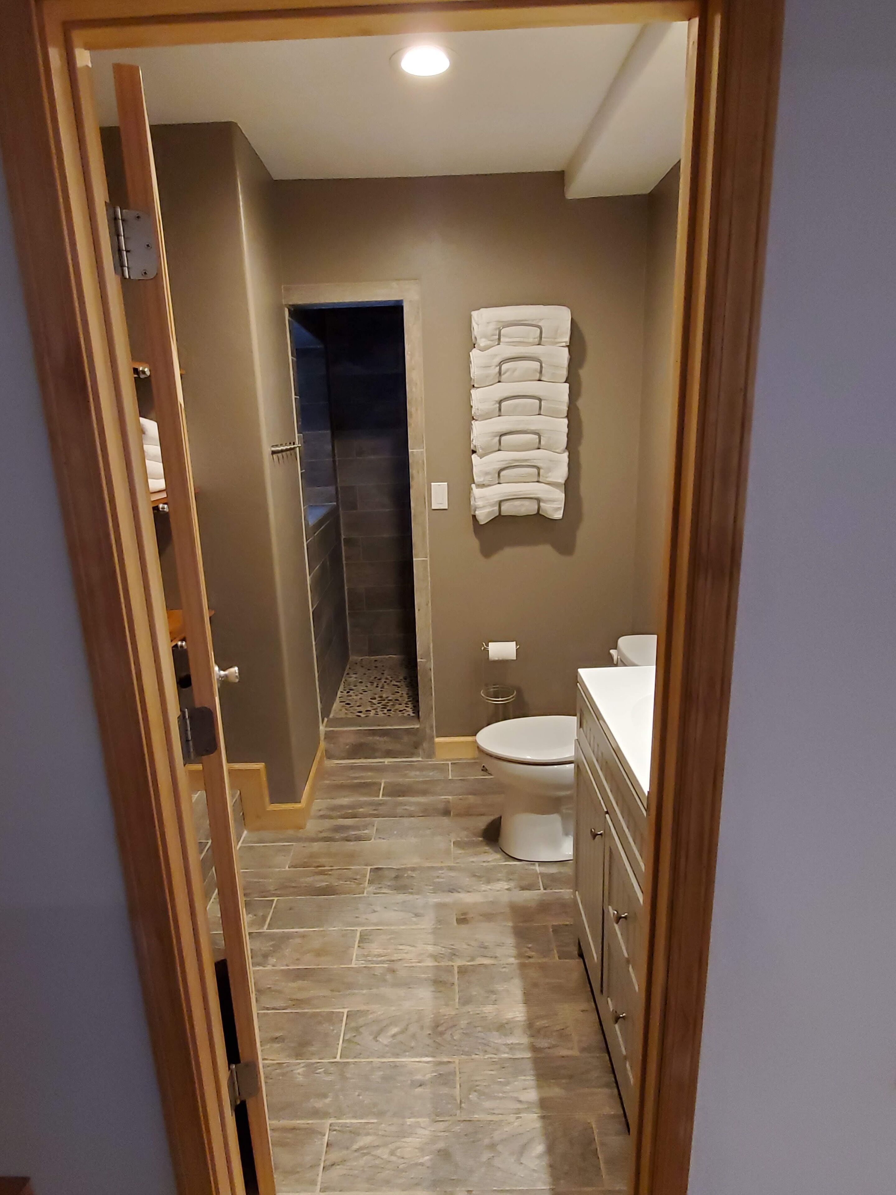 Un baño con inodoro, lavamanos y toallero.