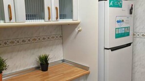 A kitchen with a wooden countertop, a refrigerator with a sticker, and cabinets with glass doors. - SAN ANGELO Levante beach apartments (Benidorm)