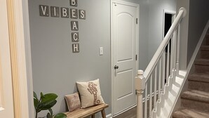 Ein Flur mit einer hölzernen Bank, einem Willkommensschild und einer Wand mit der Aufschrift "VIBESACH".