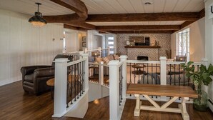 A spacious living area with a wooden staircase, a brick fireplace, and a cozy seating area. - Beautifully renovated 3,800 sq ft house between 2 federal lakes  (Lyndon)