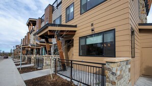 A modern multi-story residential building with a flat roof, large windows, and a stone facade. - Arrow at Winter Park Unit 248 Downtown 4 bedroom private hot tub & mountain view (Winter Park)