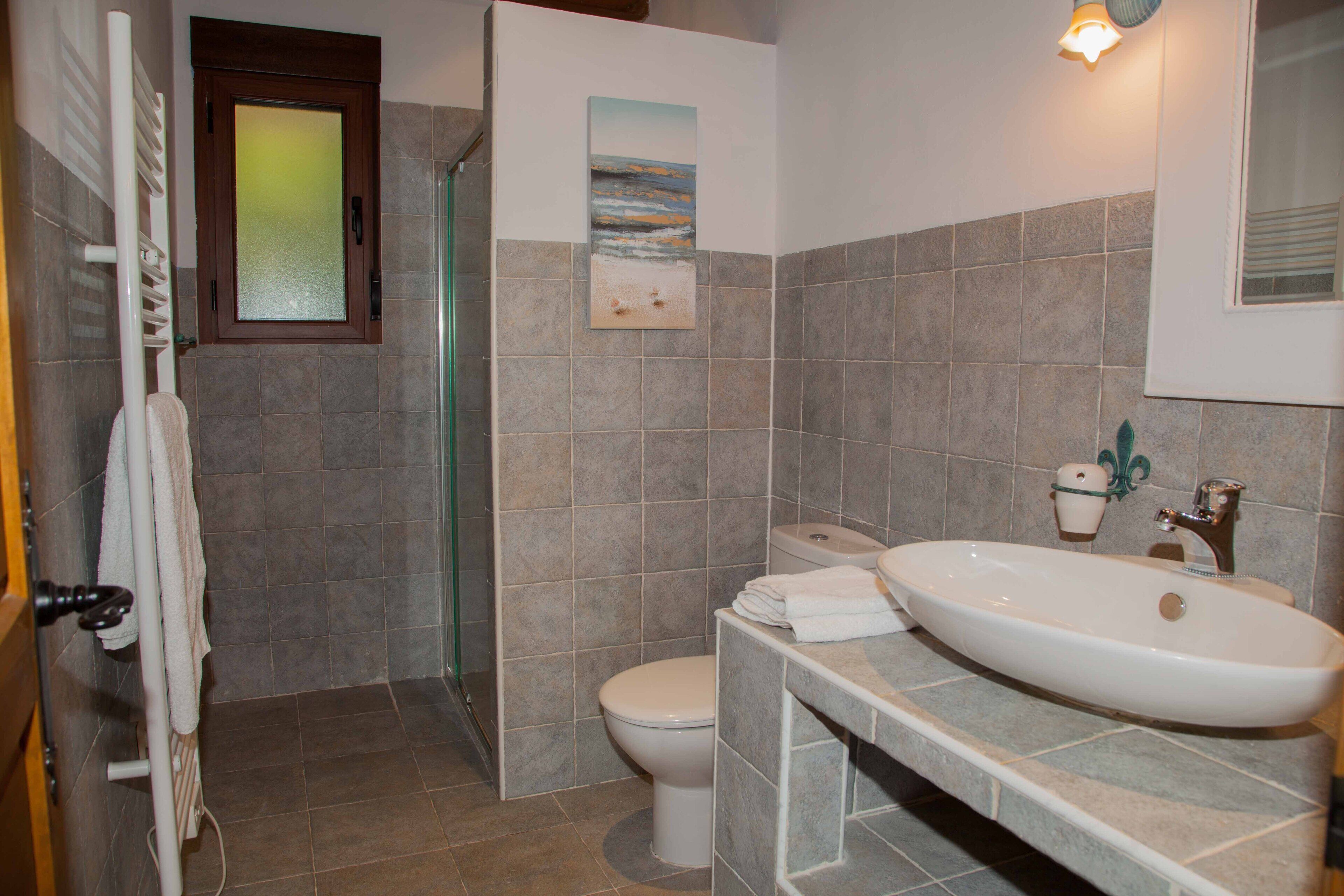 Un baño con ducha, inodoro y lavamanos.
