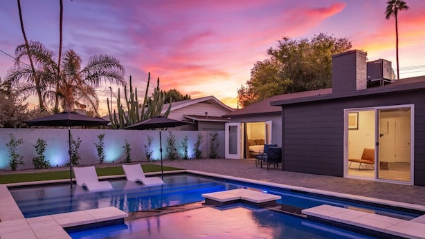 A modern house with a swimming pool, a patio with lounge chairs, and a view of the sunset. - Brand New Hot Tub & Heated Pool, Perfect Location (Scottsdale)