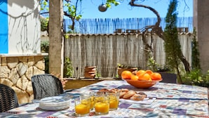 Et morgenbord med appelsinjuice, croissanter og en skål appelsiner.