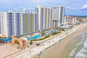 A coastal hotel with multiple high-rise buildings, a beachfront, and a pool area.