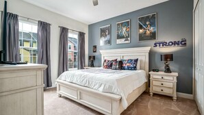 A bedroom with a large bed, a dresser, a nightstand, and Star Wars posters on the wall. - 142cd-non Renting 4/1/2022 -festival Resort (Davenport)