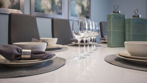A dining table set with plates, bowls, and wine glasses, with a napkin folded on the left. - 1584mc-the Retreat at Championsgate (Davenport)