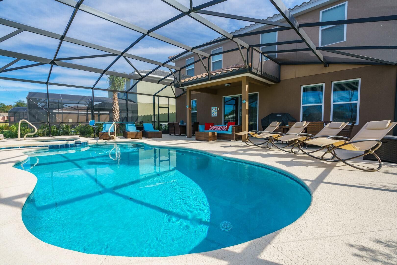 A swimming pool with lounge chairs and a covered patio area.