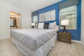 A bedroom with a large bed, a nightstand, a mirror, and a window with blinds. - 6100bod-solterra Resort (Davenport)