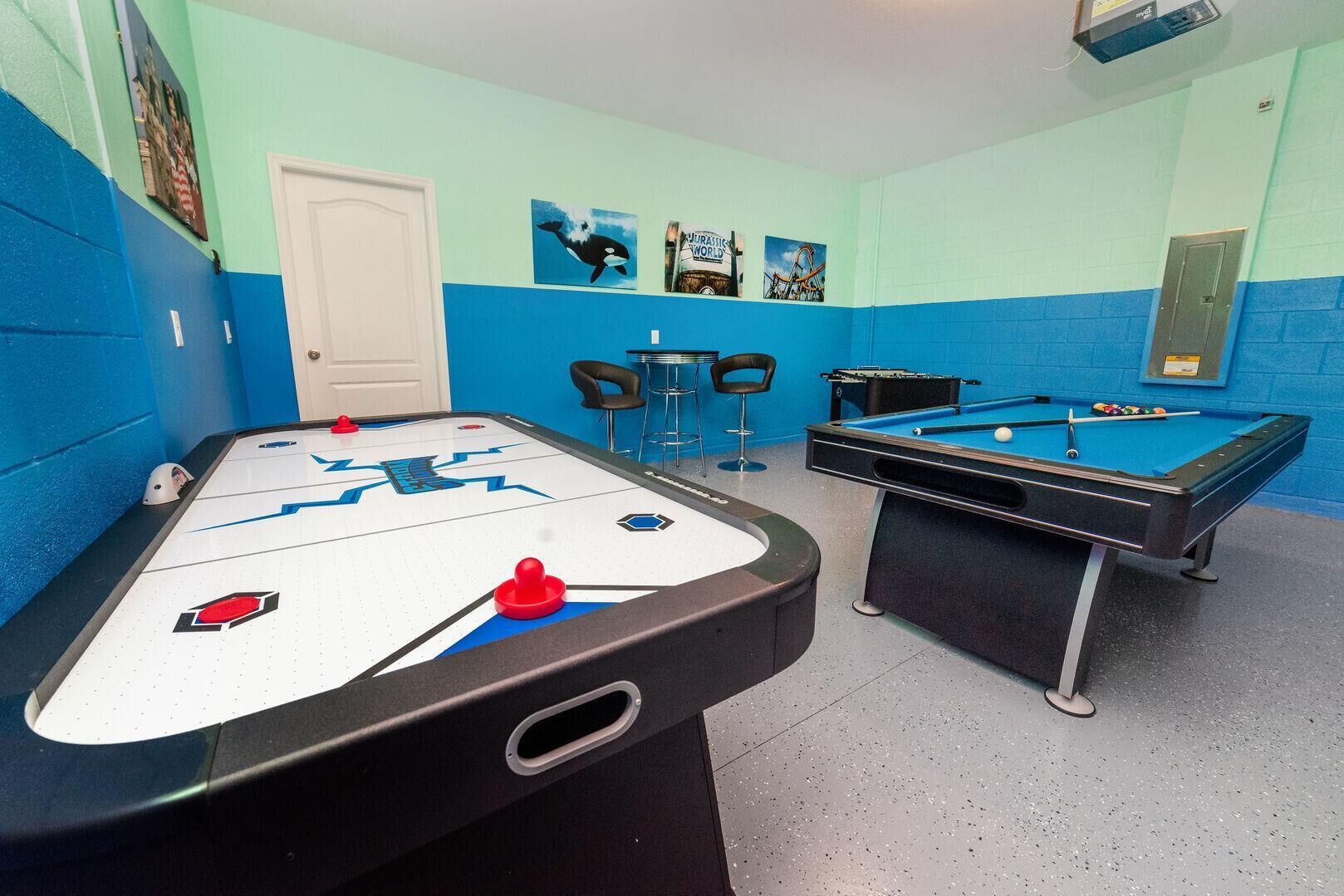 Habitació amb taula de bitlles, taula d'air hockey i dues cadires.