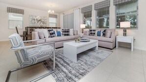 A modern living room with a sectional sofa, a coffee table, and a patterned armchair. - 6100bod-solterra Resort (Davenport)