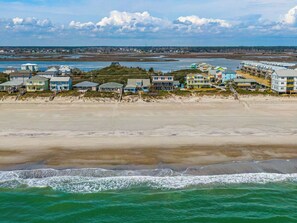 A coastal hotel with multiple buildings, a beach in the foreground, and a view of the ocean. - Surfside Cottage | Pet Friendly, Hot Tub, Views! (Topsail Beach)