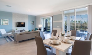 Relax in this spacious living area with a large flat-screen TV, comfortable sofa, and dining table for socializing.