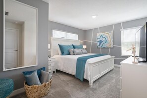 A bedroom with a bed, a dresser, a mirror, a wall art piece, and a window with blinds. - 266oca The Retreat at Championsgate (Davenport)