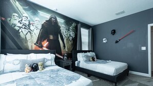 Makuuhuoneessa on kaksi sänkyä, seinällä suuri Star Wars -aiheinen seinämaalaus ja Star Wars -aiheinen kypärä.