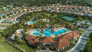 An aerial view of a residential area with a central swimming pool, surrounded by houses with red-tiled roofs, and a well-maintained lawn. - 6049bod-solterra Resort (Davenport)