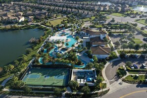 An aerial view of a residential area with a large swimming pool, tennis courts, and a lake. - 2404tgd Non Renting 11/28/2022 - Windsor at Westside (Kissimmee)
