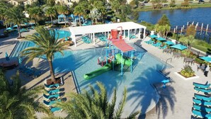 A resort pool area with multiple swimming pools, lounge chairs, and a water slide. - 2404tgd Non Renting 11/28/2022 - Windsor at Westside (Kissimmee)