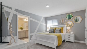 A bedroom with a bed, bedside tables, a dresser, and a wooden mannequin.