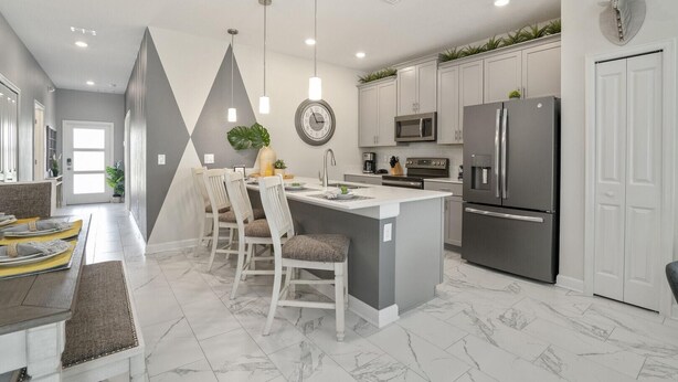 A modern kitchen with white cabinets, stainless steel appliances, and a central island with seating.