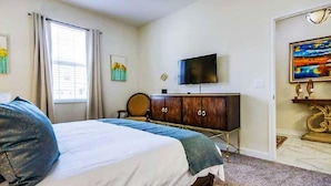 A bedroom with a bed, a television, a cabinet, and artwork on the walls. - 1516fd-the Retreat at Championsgate (Davenport)