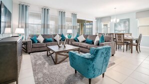 Ein modernes Wohnzimmer mit einer Sofagarnitur, einem Couchtisch und einem Essbereich mit Stühlen und einem Tisch.