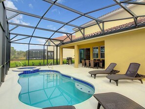 Ein überdachter Pool im Freien mit Liegestühlen und einer Grillgelegenheit.