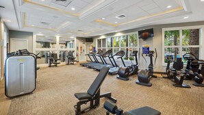 Una palestra con tapis roulant, ellittiche e attrezzature per il sollevamento pesi.