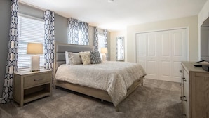 A bedroom with a bed, nightstands, a dresser, and a closet. - 720dsd-the Retreat at Championsgate (Kissimmee)