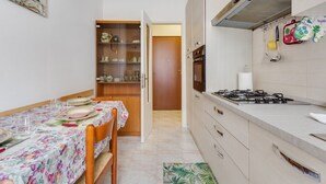 A compact kitchen with a dining area, a built-in oven, and a gas stove.